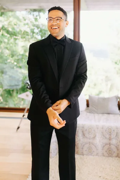   מיגל's black tuxedo with a black dress shirt and black bow tie