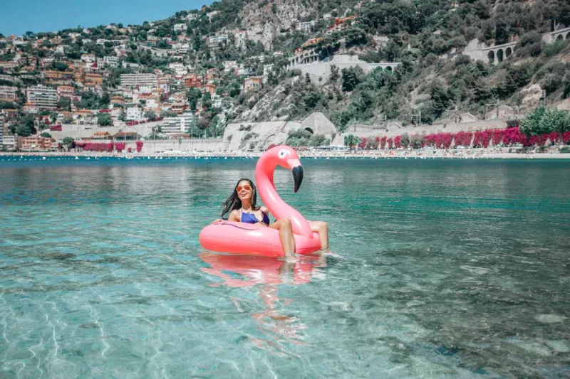   Nainen kelluu räjäytettävässä vaaleanpunaisessa flamingoputkessa meressä Nizzassa, Ranskassa.