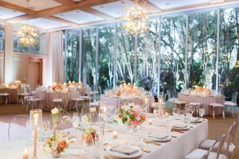   Victoria et Adrien's reception with crystal chandeliers, ghost chairs, and flowers