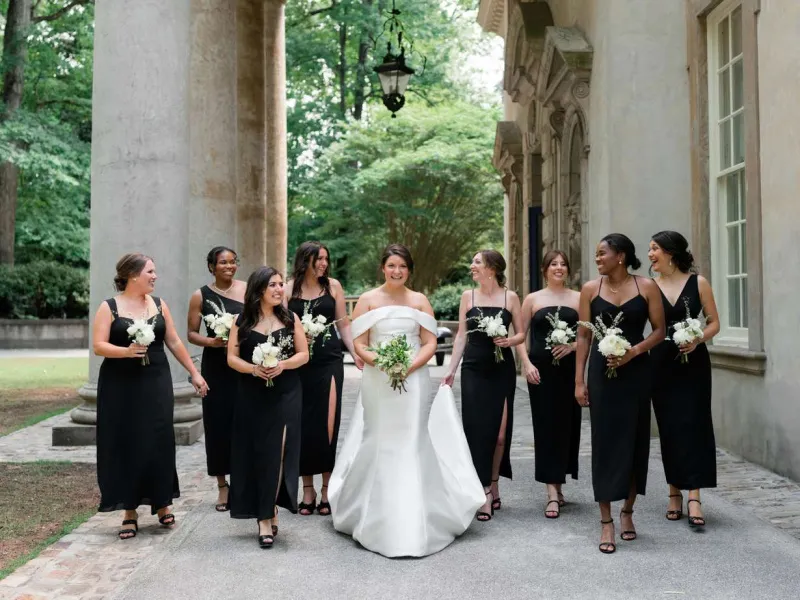   Sarah's bridesmaids in all black and carrying white bouquets 