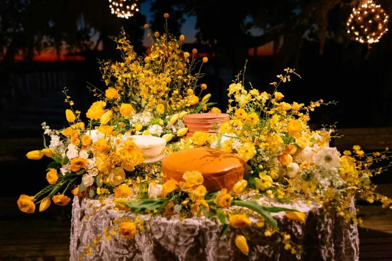   Connor i Greer's wedding cake table with yellow flowers