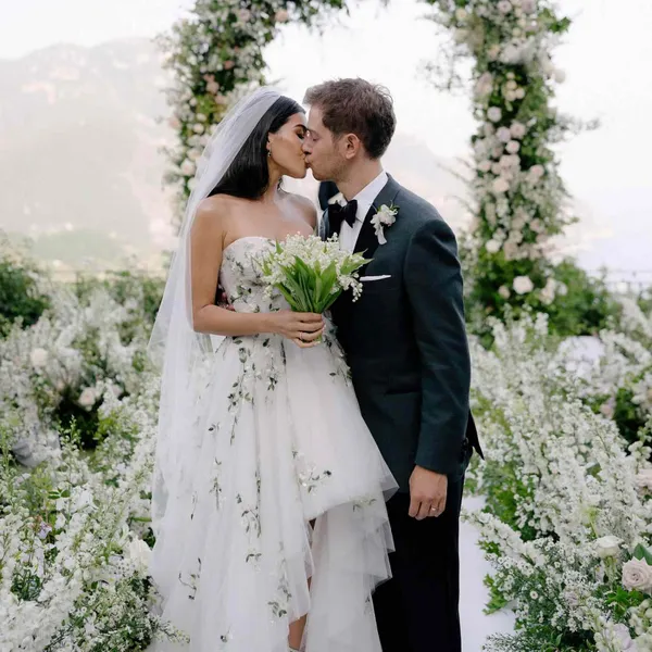   les mariés s'embrassent entourés de fleurs blanches