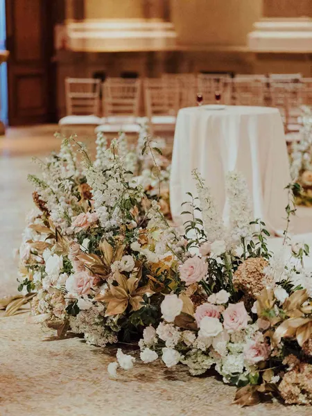   Joanna et Gabe's pink, white, and gold flowers surrounding their round stage