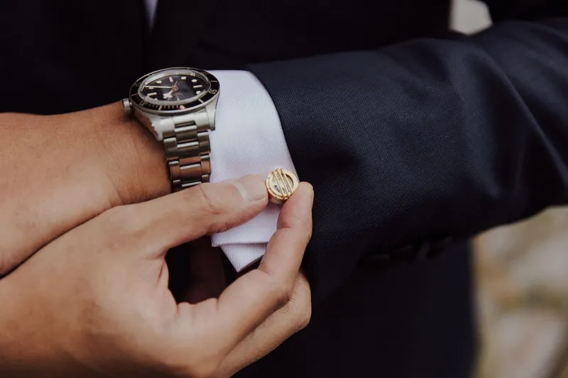   Ilman's gold cufflinks and stainless steel watch