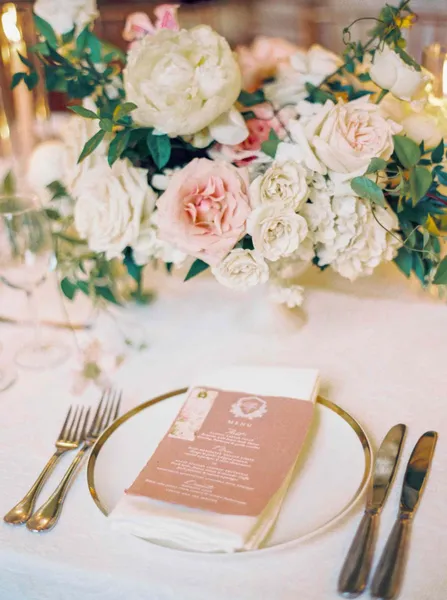   Samantha en Kenny's place settings with gold flatware and gold-rimmed chargers