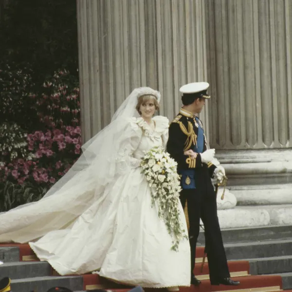   La princesse Diana dans sa robe de mariée en taffetas de soie reliant les bras au roi Charles à l'extérieur de Saint-Paul's Cathedral