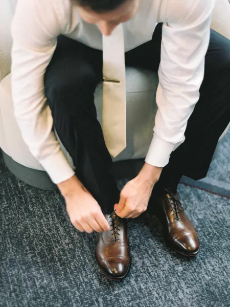   JP met des mocassins marron dans une chemise boutonnée, une cravate en soie et un pantalon noir
