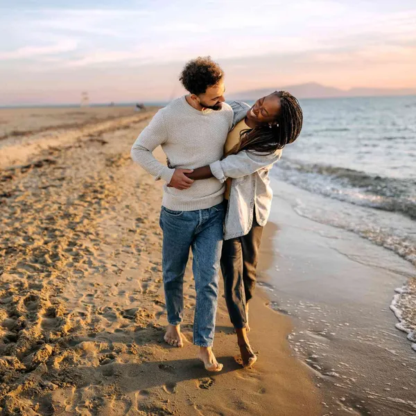   Un couple noir profite d'une escapade romantique sur la plage au bord de l'océan.