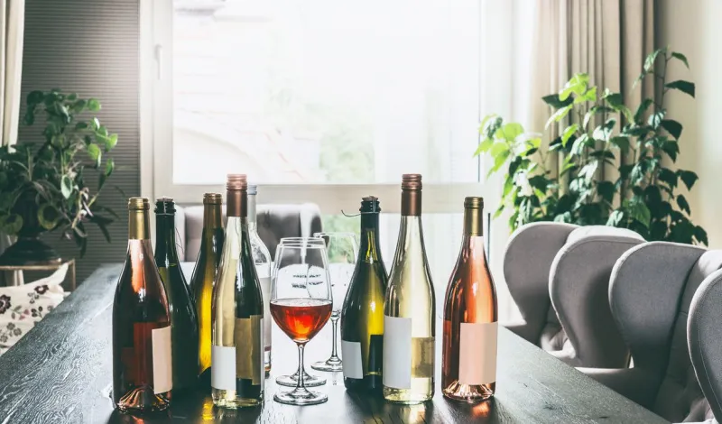   Raznolikost bijelog vina, crnog vina i rosea sjedi na stolu s vinskom čašom.