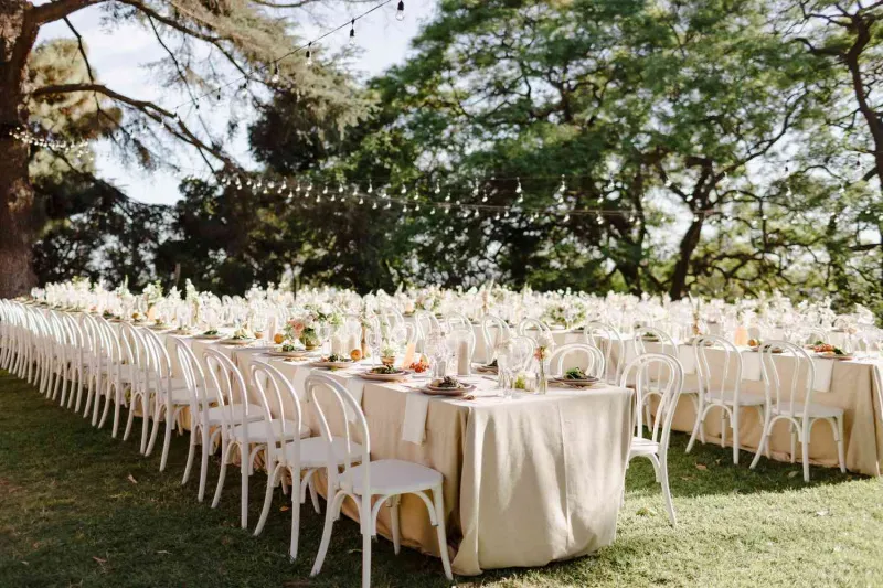   Mégane et Thomas's outdoor reception with banquet tables and neutral tablecloths