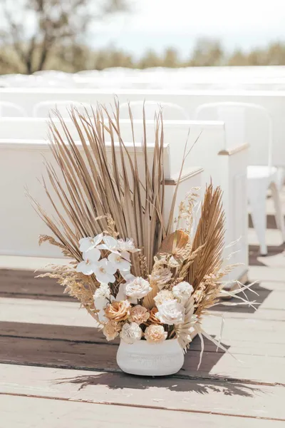   Kenzie i Jake's arrangements of dried palm leaves and flowers in white and orange hues