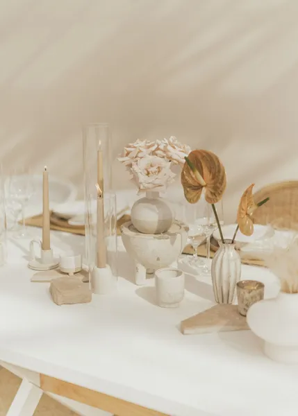   Kenzie et Jake's centerpieces with beige taper candles, single-stem flowers in boho cases, and stones